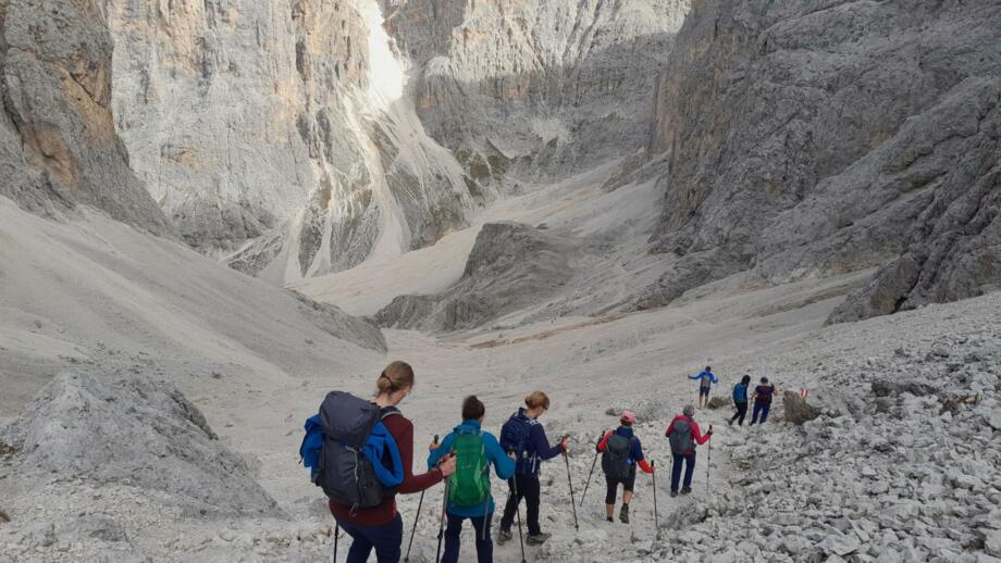Wandergruppe in den Dolomiten beim Abstieg im gerölligen Gelände