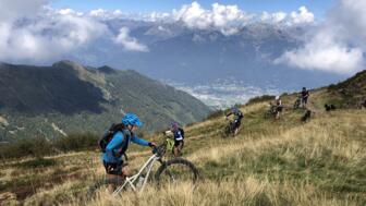 Eine Gruppe Mountainbiker*innen während einer Schiebepassage im Anstieg.