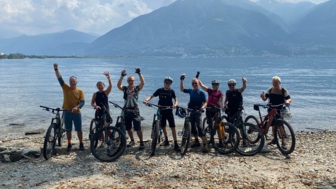 Eine Mountainbike-Gruppe nach einer erfolgreichen Transalp am Ziel dem Lago Maggiore angekommen.