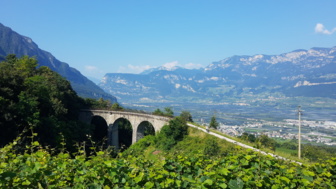 Auf der MTB Transalp die Landschaft Südtirols erleben: Eine Viaduktbrücke mit dem Ausblick in die Talebene und auf die umliegende Bergwelt.